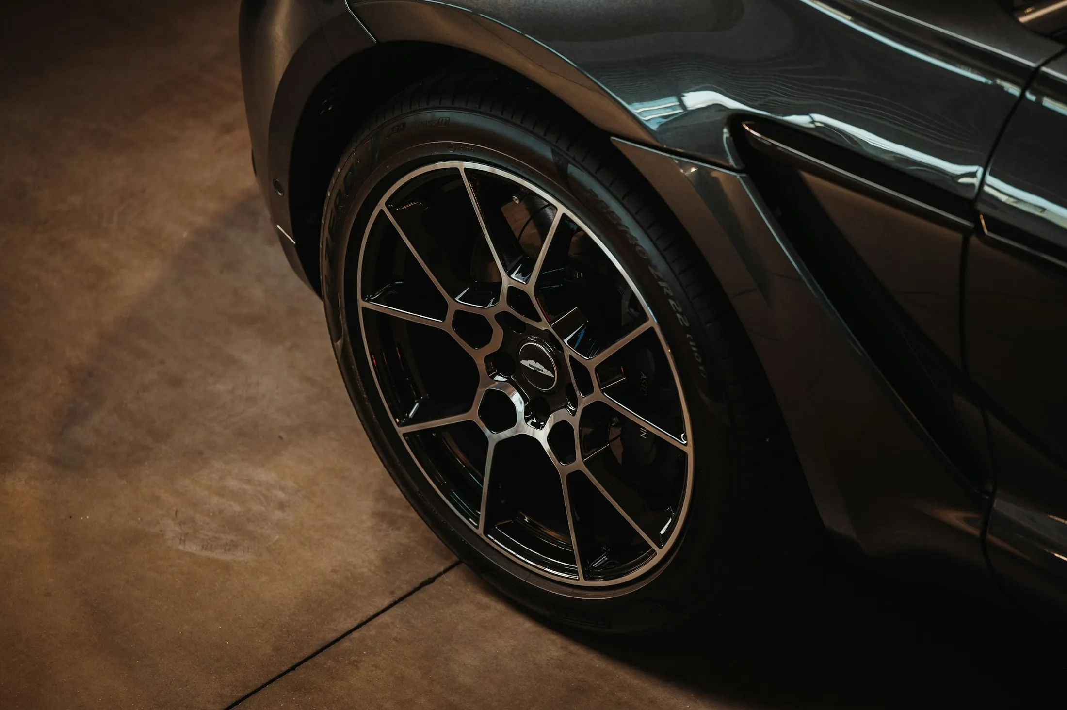 Dark sports car parked on a glossy garage floor